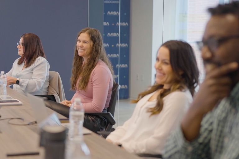 four adults sitting at a table smiling